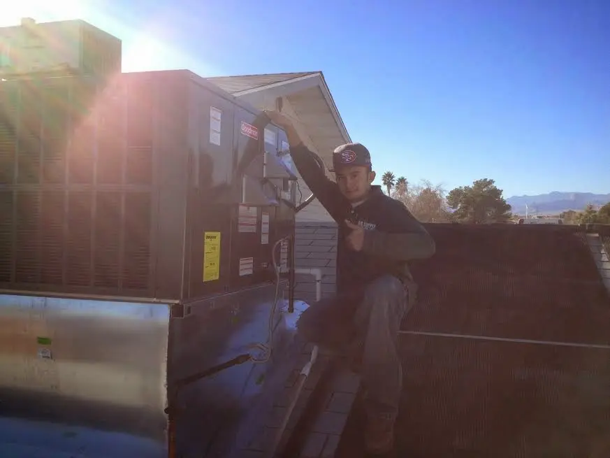 HVAC technician performing AC Tune-Up on a rooftop unit in Chickasha